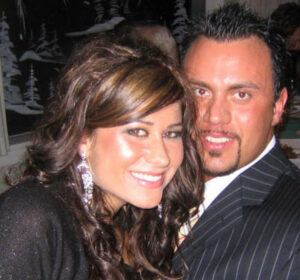 young dark haired woman and a tanned young man with a thin moustache and beard, smiling 