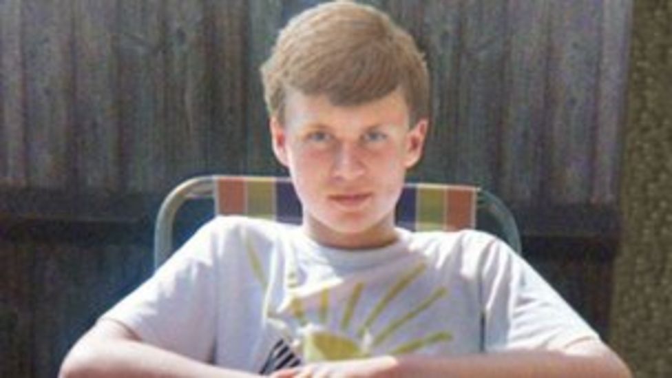 a young lad,15, with light brown hair sits and looks into the camera.